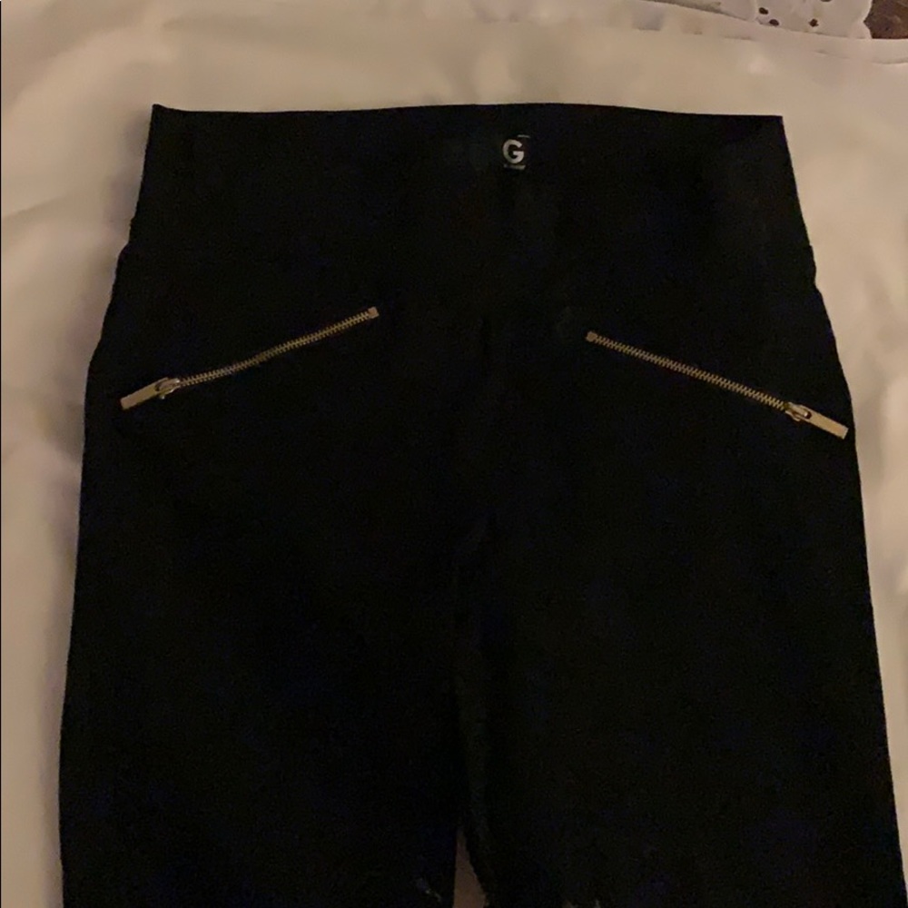 Stretch pants with gold zippers on front